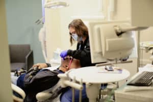 dental assistant working on patient's teeth